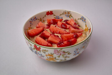 Delicious Bowl of Oatmeal Topped with Fresh Strawberries and a Touch of Sweet Syrup for a Perfect Breakfast Option