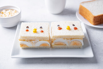 Japanese Egg Salad sandwich, Tamago Sando in the form of funny face on a white background