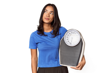 Filipino woman with scale in studio dreaming of achieving goals and purposes