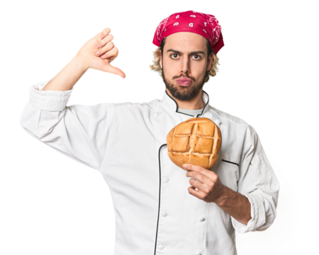 Young chef with artisan bread in studio feels proud and self confident, example to follow.