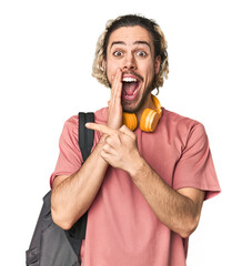 Young student with backpack and headphones saying a gossip, pointing to side reporting something.