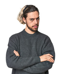 Young Caucasian man in studio setting suspicious, uncertain, examining you.