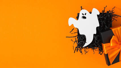 Halloween themed shopping sale. Open black gift with cute ghost on orange background. Happy...