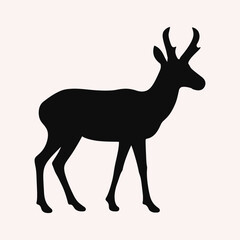 Silhouette of a pronghorn antelope standing gracefully against a soft pink background