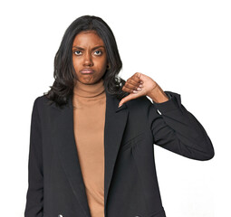 Young Indian woman in business suit showing a dislike gesture, thumbs down. Disagreement concept.