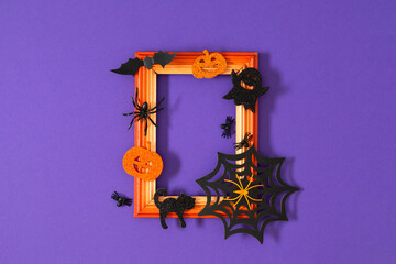 Orange wooden Halloween frame with themed decorations pumpkins, bats, spider webs and ghosts, top...