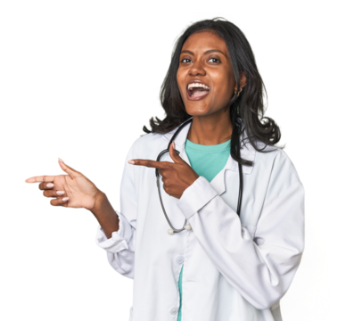 Young Indian doctor with stethoscope pointing with forefingers to a copy space, expressing excitement and desire.