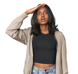 Portrait of a young Indian woman shouts loud, keeps eyes opened and hands tense.