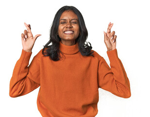 Portrait of a young Indian woman crossing fingers for having luck