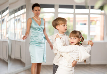 Passionate tween dancers, girl and boy practicing ballroom dancing in dance studio, gracefully...