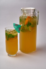 Refreshing Tropical Beverage with Citrus and Mint in a Glass and Pitcher, Perfect for Warm Days and...