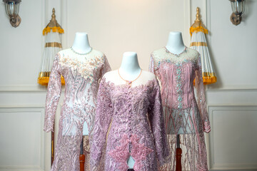 Three pastel bridal gowns with luxurious embroidery and sequin details, elegantly displayed on...