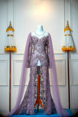 Sophisticated lilac gown with intricate embroidery and sheer long sleeves, featuring a front slit...