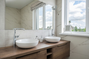 Modern bathroom design featuring sleek sinks and natural light in a spacious setting
