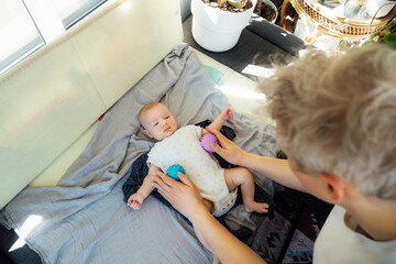 Father massages baby with massage ball. Healthy massage. Massage therapist. Sensory tactile...