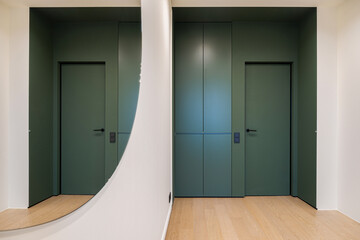 Modern hallway design featuring elegant green doors and minimalist decor in a stylish interior space