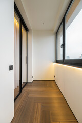 Modern interior design of a sunlit balcony area with sleek lines and warm wood flooring showcasing minimalist elements in a contemporary setting