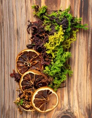 Dried Citrus Slices and Green Moss on Rustic Wood Surface Creates a Still Life