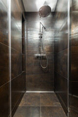 Modern shower design featuring sleek dark tiles and a stylish showerhead in a contemporary bathroom