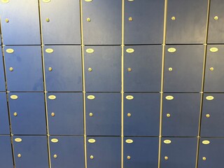Wall of small navy blue lockers in public space, orderly and symmetrical, secure storage for...