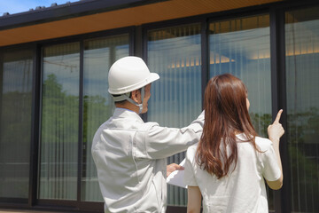 住宅の打ち合わせをする建築業者と女性