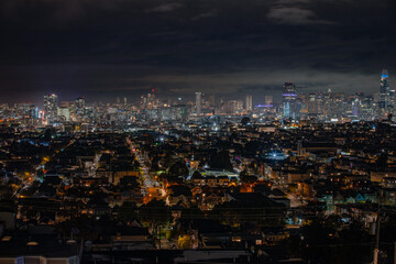 Obraz premium A panoramic night view of San Francisco's cityscape with glowing buildings and a sprawling urban landscape.