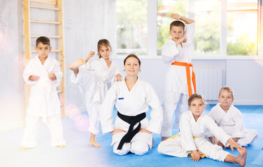 Obraz premium Portrait of female karate or judo coach with her students little children in the gym