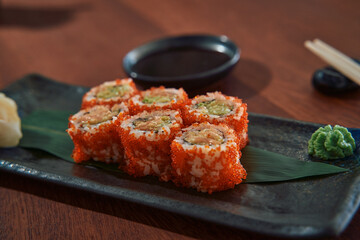 Delicious Sushi Platter Featuring Colorful Rolls on a Rustic Black Plate with Accompaniments of Wasabi and Soy Sauce for an Authentic Culinary Experience