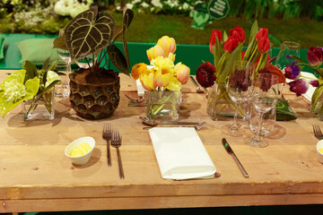 Elegant dining table set with colorful flowers, glassware, and cutlery for a festive occasion