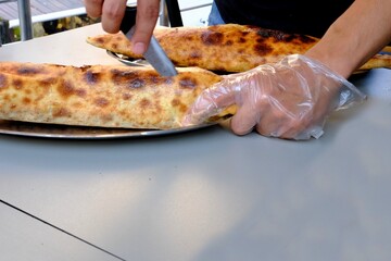 A chef pours butter into a traditional Turkish culinary delight: ground meat pide. Buttered ground meat pide is accompanied by buttermilk in a copper mug. Pastries. Food industry. Ramadan, iftar.
