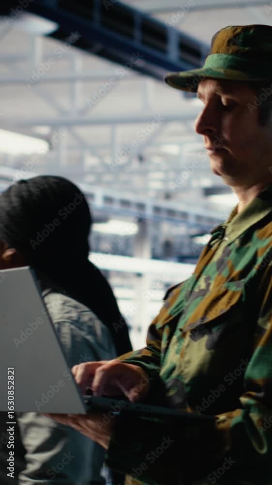 Poster vertical video soldier in server hub using laptop to deploy ai tech, modernizing defense infrastruct