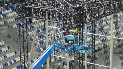 Music concert stage set up buildup construction. stadium football pitch being prepared to host a music concert. sports stadium as technicians set up the stage for the live music event. - Powered by Adobe