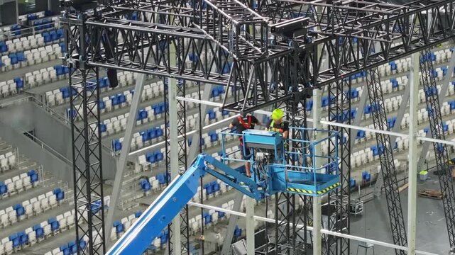 Music concert stage set up buildup construction. stadium football pitch being prepared to host a music concert. sports stadium as technicians set up the stage for the live music event.