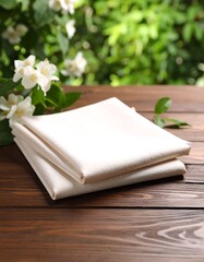 Cream napkins on a wooden table with flowers