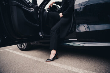 Elegant woman stepping out of a car in an urban setting, exuding professionalism and sophistication...