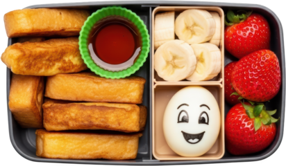 Bento box containing stacked french toast sticks sliced bananas strawberries and a happy face boiled egg transparent background