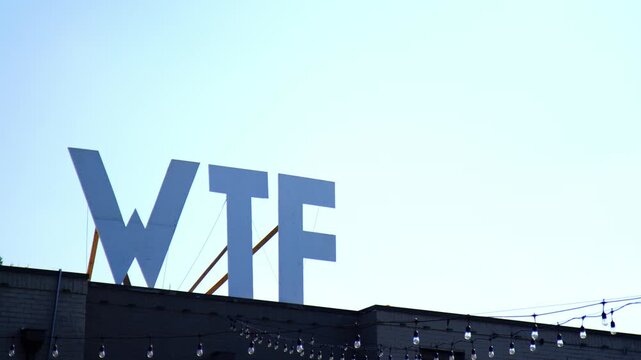 Funny WTF Sign on Rooftop with Birds in the Background