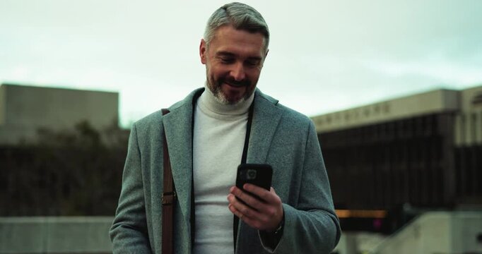 Phone, thinking and walking with businessman in city to check agenda or schedule for travel. App, communication and planning with happy mature employee outdoor in urban town for commute to work