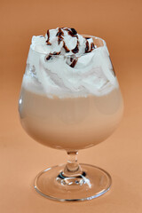 Creamy Chocolate Dessert Beverage Topped with Whipped Cream and Drizzled Chocolate Sauce on a Beautiful Amber Background