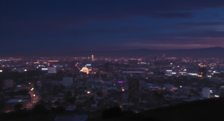 Obraz premium Nighttime Cityscape: Illuminated Buildings Under a Darkening Sky.