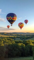 Naklejka premium Colorful hot air balloons floating over a lush green landscape at sunset with a clear blue sky above