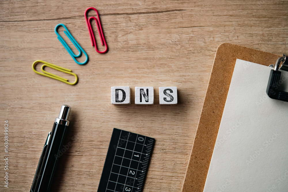 Aufkleber there is wood cube with the word dns. it is an abbreviation for domain name system as eye-catching i