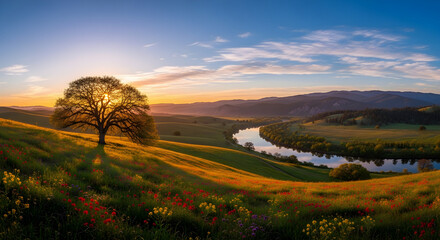Obraz premium The golden light of a serene sunset bathes a solitary tree on a verdant hill with wildflowers, overlooking a peaceful river valley.