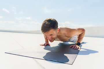 Dynamic push-up workout session on a rooftop overlooking the city skyline with a determined athlete embracing fitness and strength