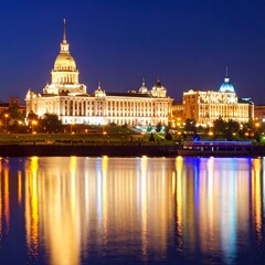 Fototapeta premium City buildings by night reflecting on water