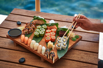 An Exquisite Platter of Sushi Artfully Presented on a Wooden Board, Featuring Diverse Varieties...