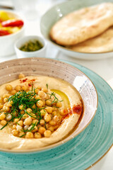 Delicious Chickpea Hummus with Fresh Garnishes Served in a Vibrant Bowl Accompanied by Soft Flatbreads Perfect for Dipping and Enjoying Flavors