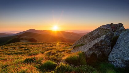 sunrise over a high grassy plateau rocky outcrop foreground