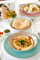 A Vibrant Array of Middle Eastern Cuisine Featuring Rich Hummus, Fluffy Pita Bread, and Fresh Ingredients Displayed Beautifully on a Dining Table