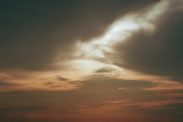 Dramatic sunset sky with a prominent, bright cloud formation. Warm colors dominate the scene.